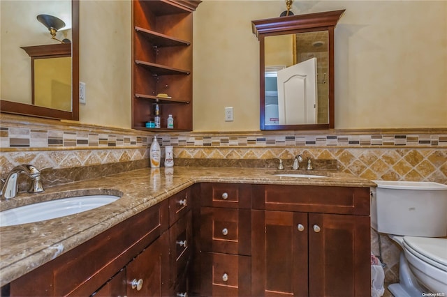 bathroom featuring vanity, toilet, and backsplash