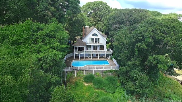 rear view of house with a fenced in pool