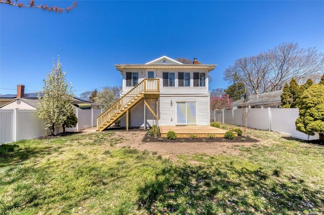 back of property with a lawn and a wooden deck