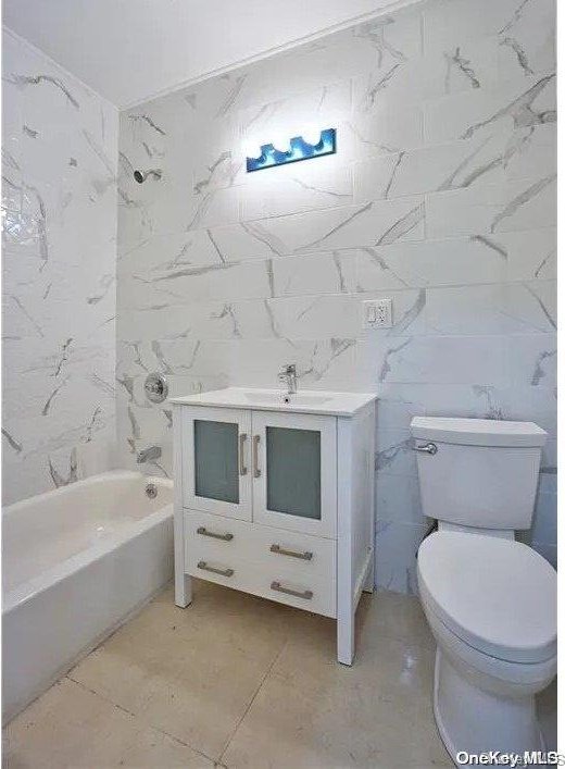 bathroom featuring tile patterned flooring, vanity, toilet, and tile walls