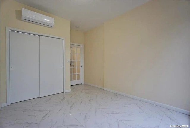 unfurnished bedroom with an AC wall unit and a closet