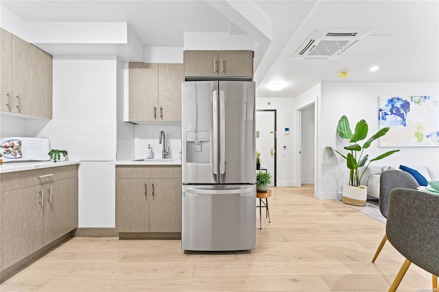 kitchen with light brown cabinets, stainless steel fridge with ice dispenser, sink, and light hardwood / wood-style flooring