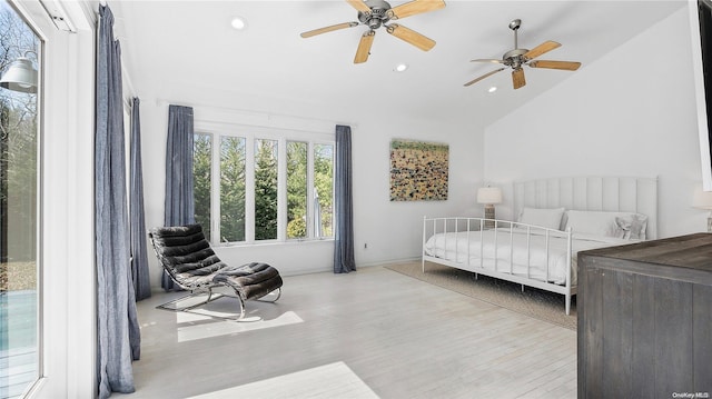 bedroom with ceiling fan, lofted ceiling, and light wood-type flooring