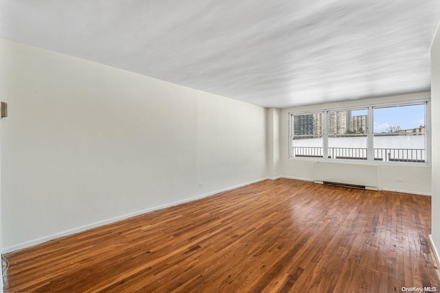 spare room with hardwood / wood-style flooring and radiator