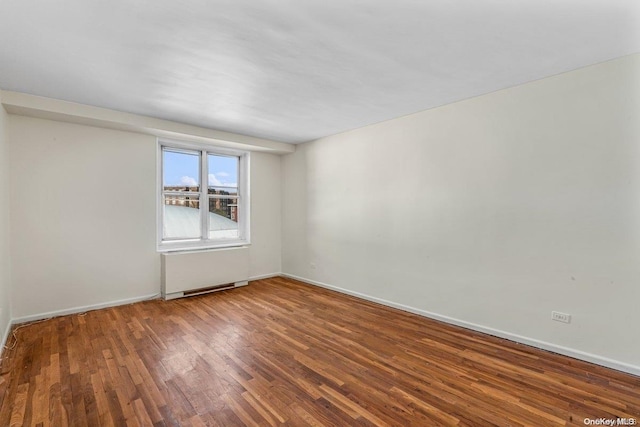 unfurnished room with wood-type flooring and radiator