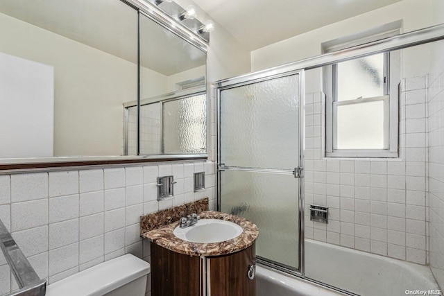 full bathroom with vanity, decorative backsplash, toilet, enclosed tub / shower combo, and tile walls