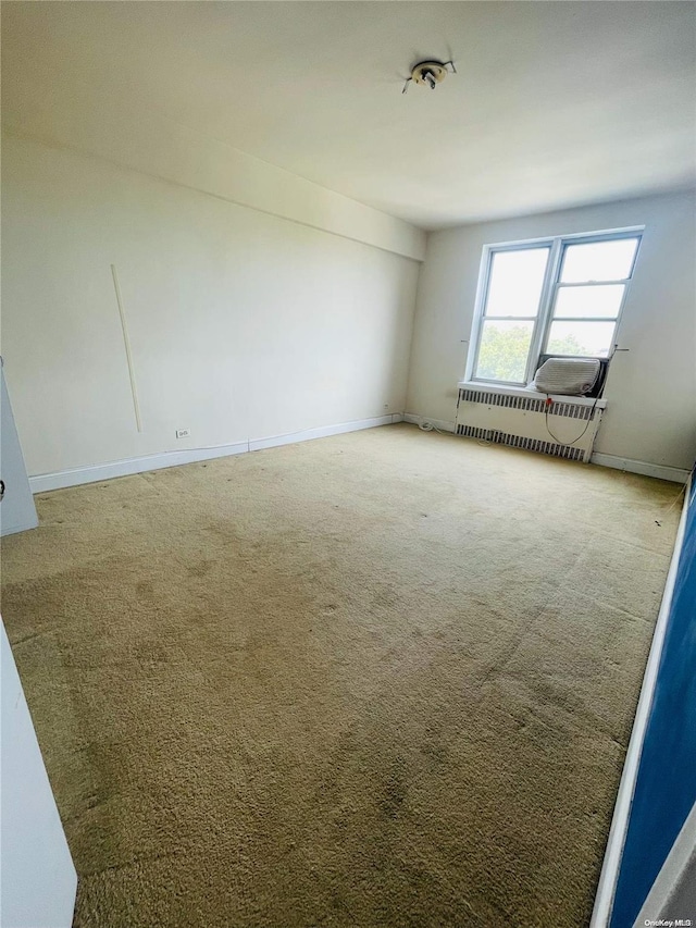 unfurnished room with carpet and radiator