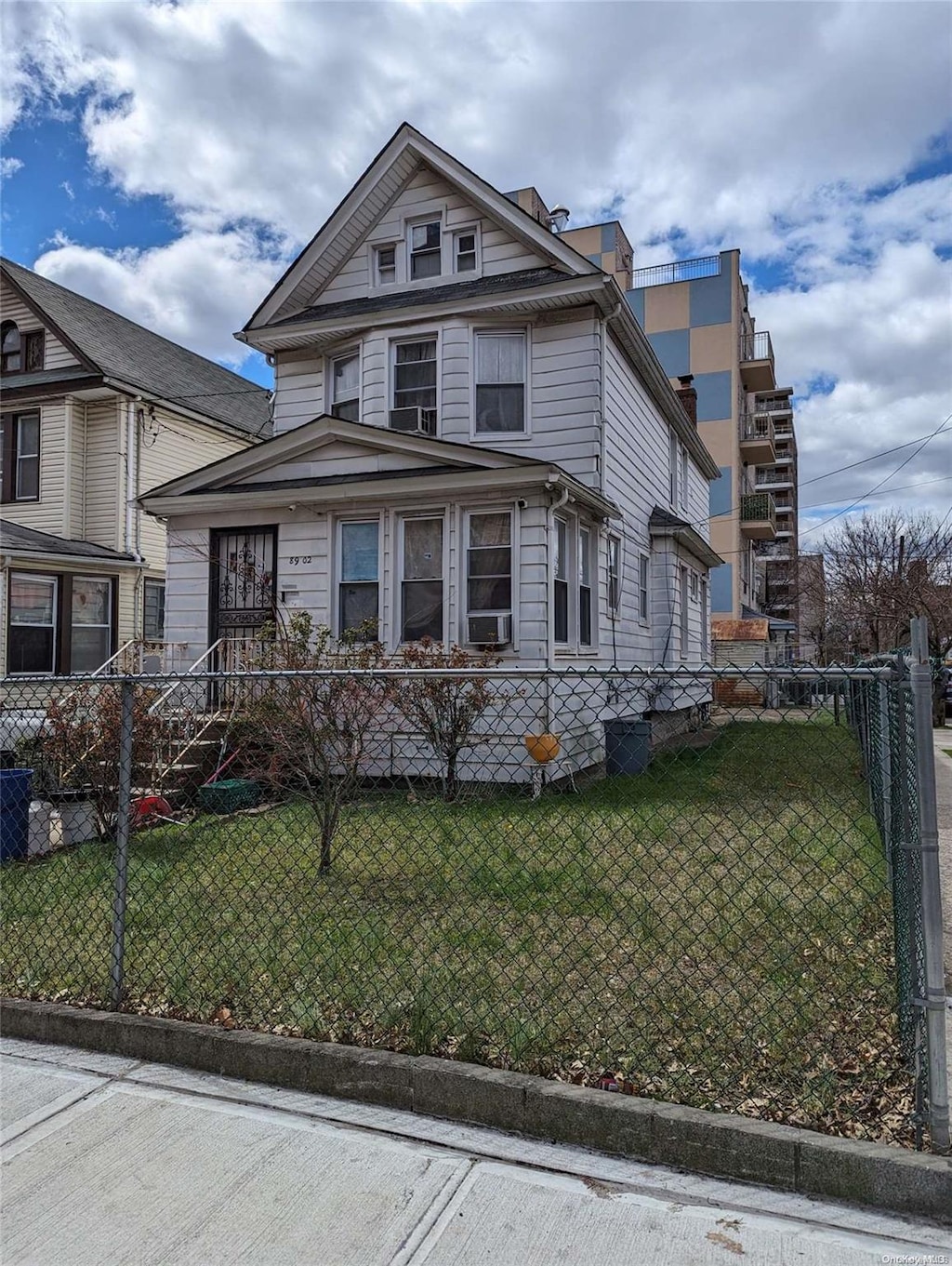 view of front of home featuring cooling unit and a front lawn