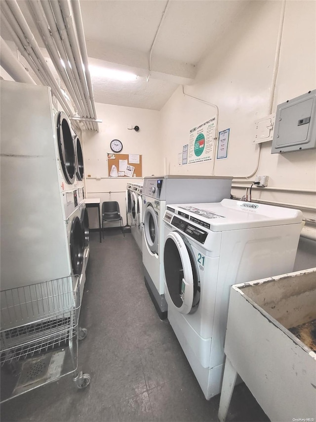 laundry area featuring stacked washer / drying machine, sink, electric panel, and washing machine and clothes dryer