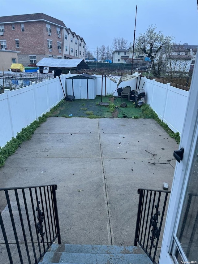 view of yard featuring a storage shed and a patio