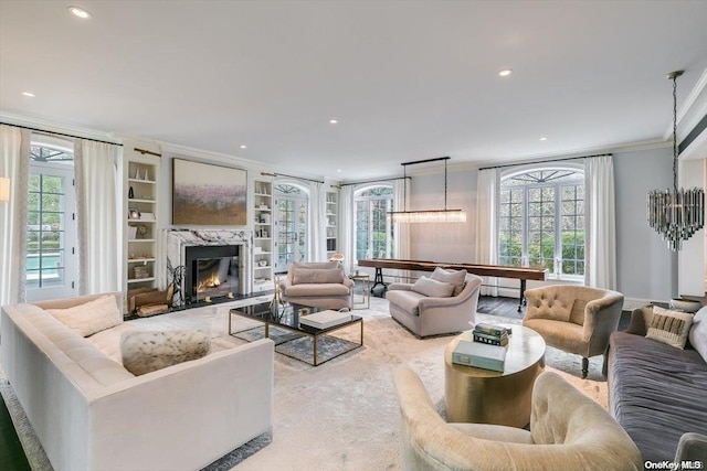 carpeted living room featuring a high end fireplace, built in shelves, and crown molding