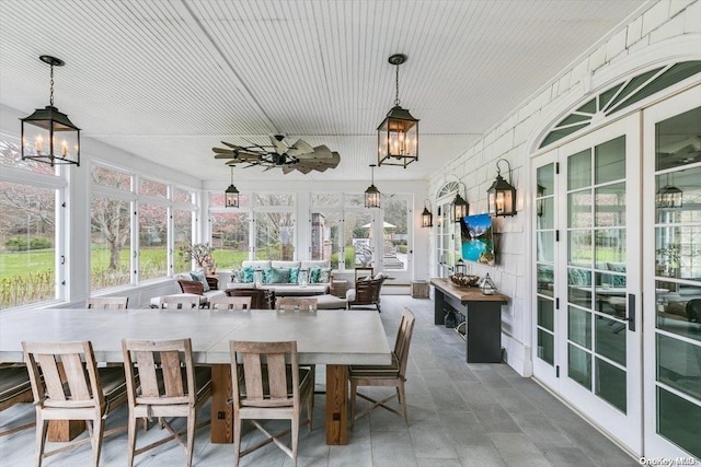 sunroom / solarium with french doors and ceiling fan with notable chandelier