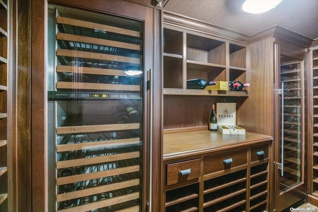 wine area with a textured ceiling and beverage cooler