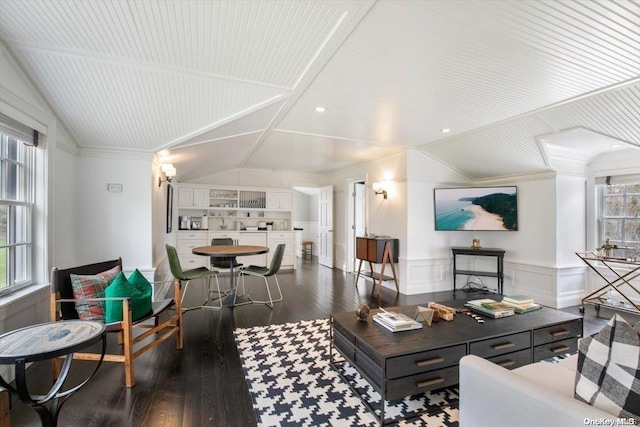 living room with a wealth of natural light, dark hardwood / wood-style flooring, crown molding, and lofted ceiling