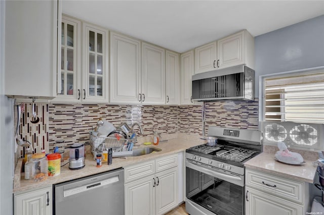 kitchen featuring decorative backsplash, light stone countertops, and appliances with stainless steel finishes