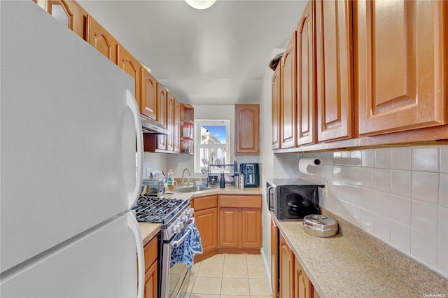 kitchen with backsplash, sink, light tile patterned floors, and stainless steel appliances