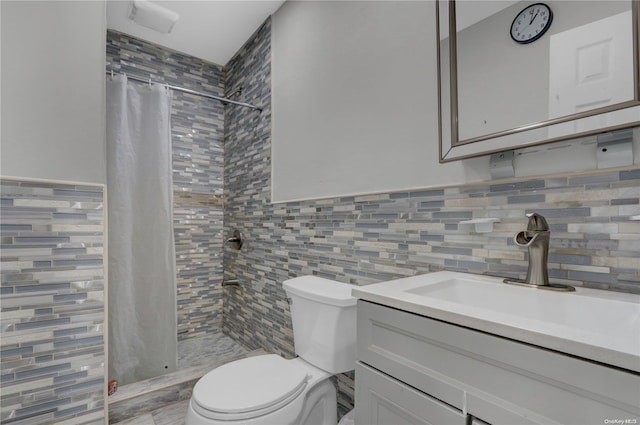 bathroom with a shower with shower curtain, vanity, toilet, and tile walls