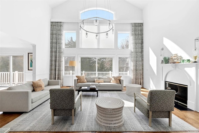 living room featuring hardwood / wood-style floors, high vaulted ceiling, and a notable chandelier