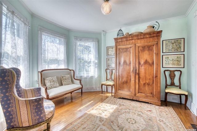 sitting room featuring light wood-type flooring and crown molding