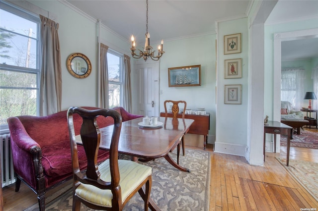 dining room featuring crown molding, light hardwood / wood-style floors, and an inviting chandelier