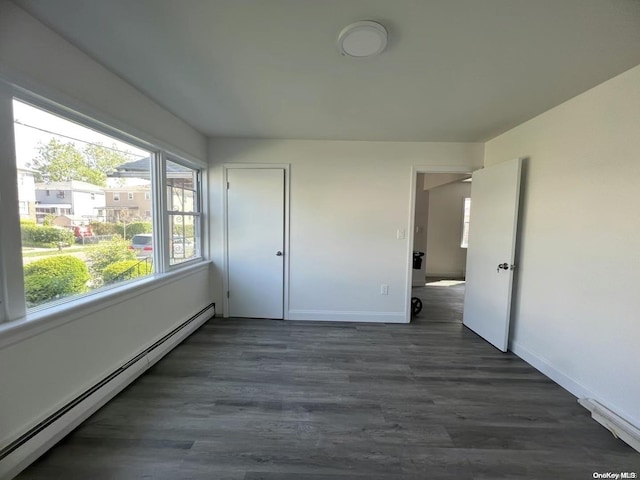 unfurnished bedroom featuring a baseboard radiator and dark wood-type flooring