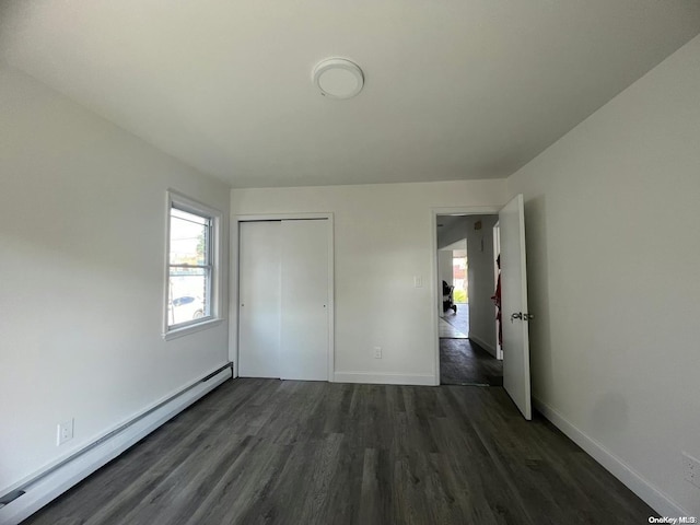 unfurnished bedroom featuring a closet, dark wood-type flooring, and a baseboard radiator