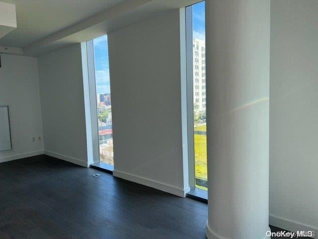 empty room with dark wood-type flooring