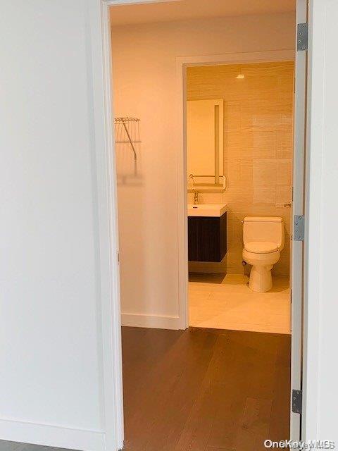 bathroom with toilet, vanity, and hardwood / wood-style flooring