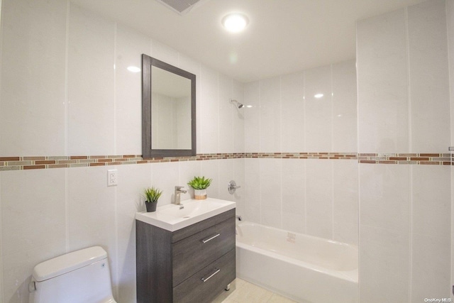 full bathroom with vanity, toilet, tile walls, and tiled shower / bath combo