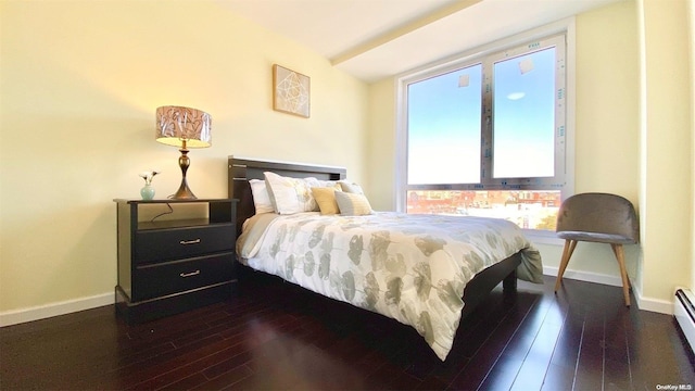 bedroom with baseboard heating and dark wood-type flooring