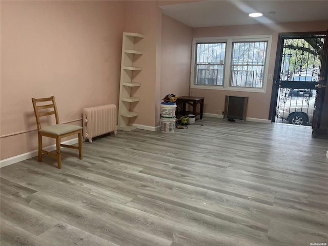 living area with light hardwood / wood-style flooring and radiator