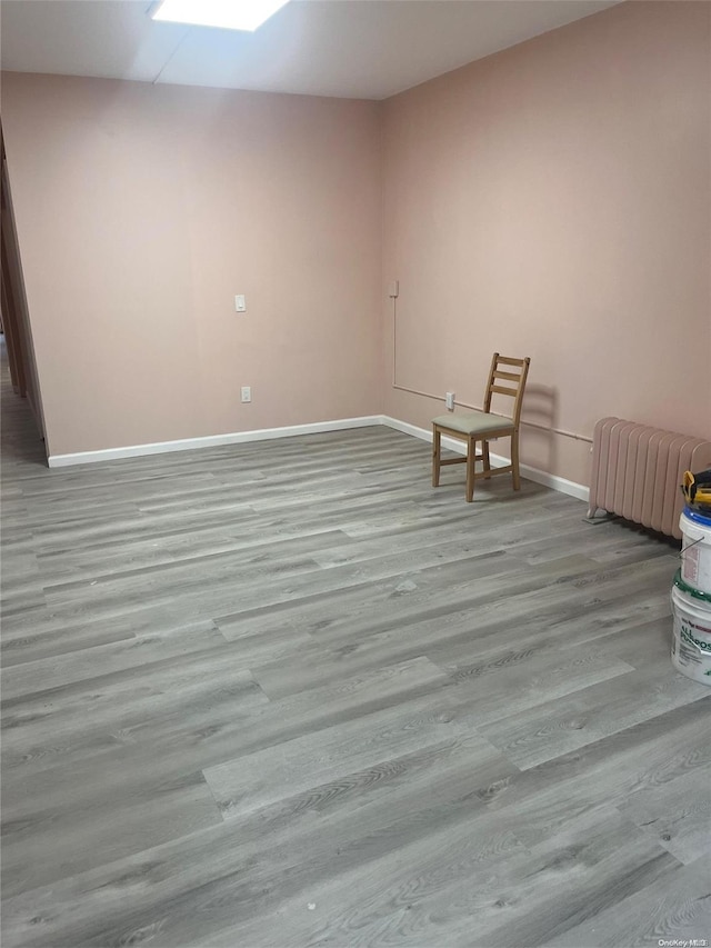 unfurnished room with light hardwood / wood-style floors and radiator