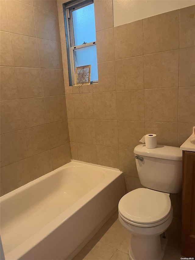 full bathroom featuring tile patterned floors, bathing tub / shower combination, toilet, vanity, and tile walls