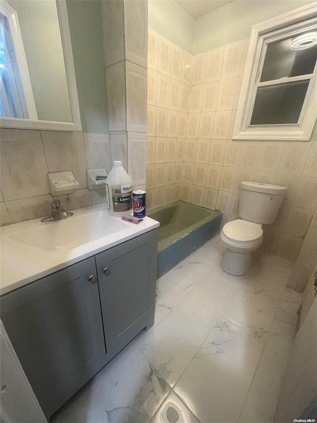 bathroom with vanity, tile walls, and toilet