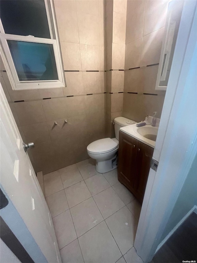 bathroom featuring tile patterned floors, vanity, tile walls, and toilet