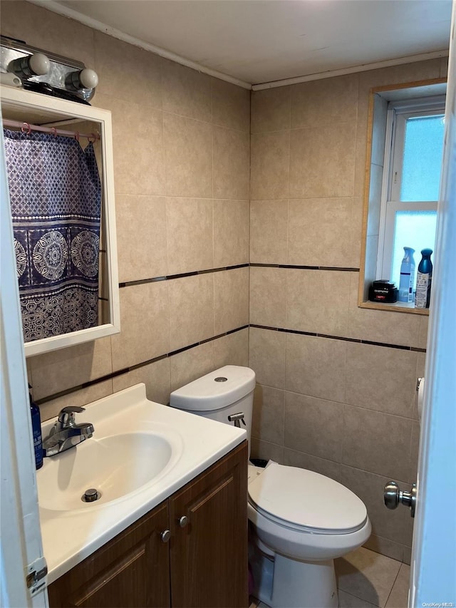 bathroom with tile patterned floors, vanity, tile walls, and toilet