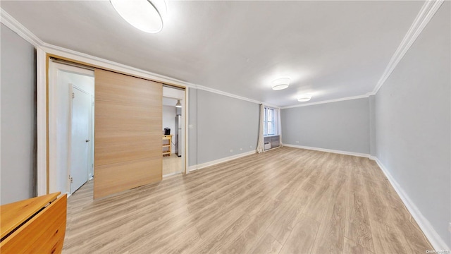 unfurnished bedroom featuring light wood-type flooring, crown molding, and a closet