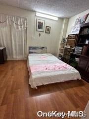 bedroom with hardwood / wood-style floors and a textured ceiling