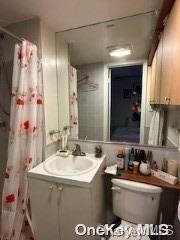 bathroom featuring vanity, a shower with shower curtain, and toilet