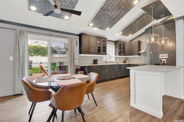 dining room featuring ceiling fan, sink, and light hardwood / wood-style flooring