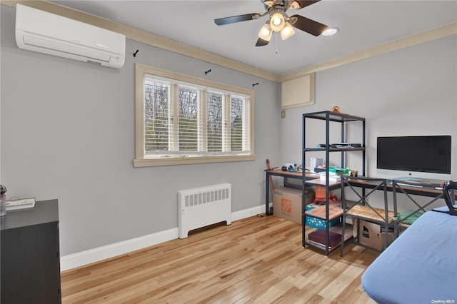 home office featuring ceiling fan, light wood-type flooring, an AC wall unit, and radiator