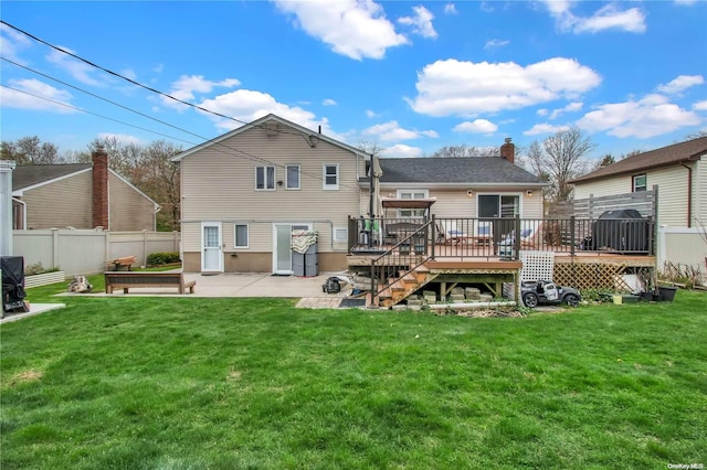 rear view of house featuring a wooden deck, a patio area, and a yard