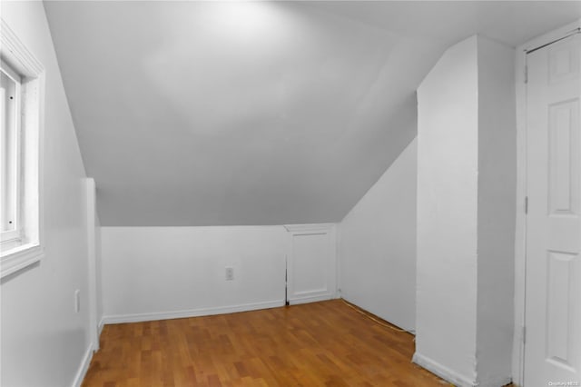 additional living space featuring light hardwood / wood-style floors and lofted ceiling