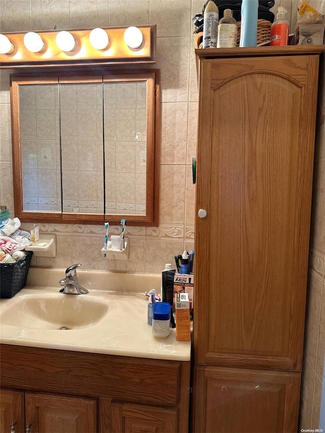 bathroom featuring vanity and tile walls