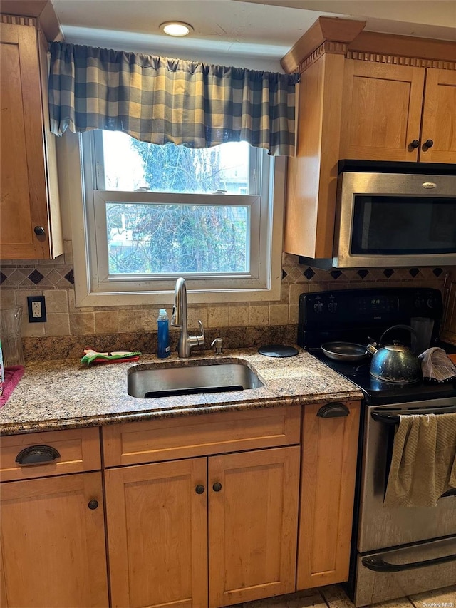 kitchen featuring backsplash, black electric range oven, light stone countertops, and sink