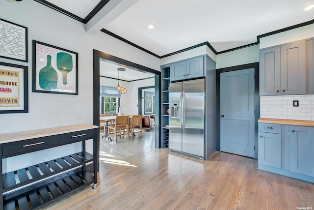 kitchen featuring tasteful backsplash, light hardwood / wood-style flooring, stainless steel refrigerator with ice dispenser, butcher block countertops, and pendant lighting