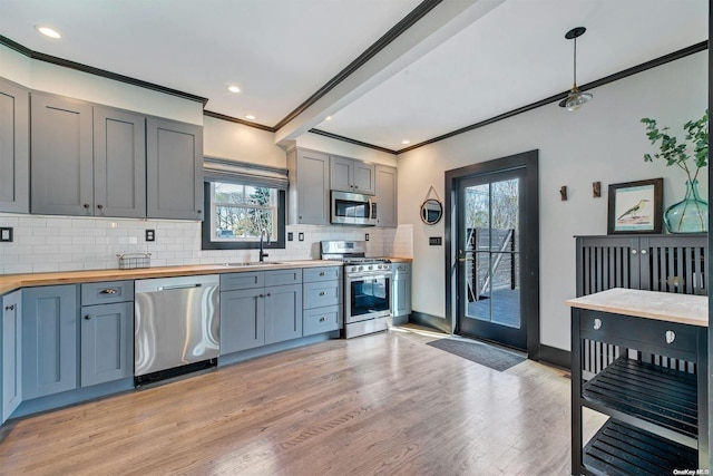 kitchen featuring sink, stainless steel appliances, plenty of natural light, and light hardwood / wood-style floors