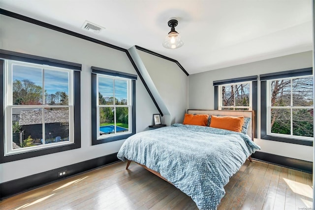 bedroom with wood-type flooring and ornamental molding