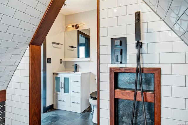 bathroom with vanity, tile walls, and toilet