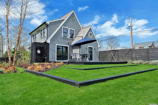 back of property featuring a lawn and a wooden deck